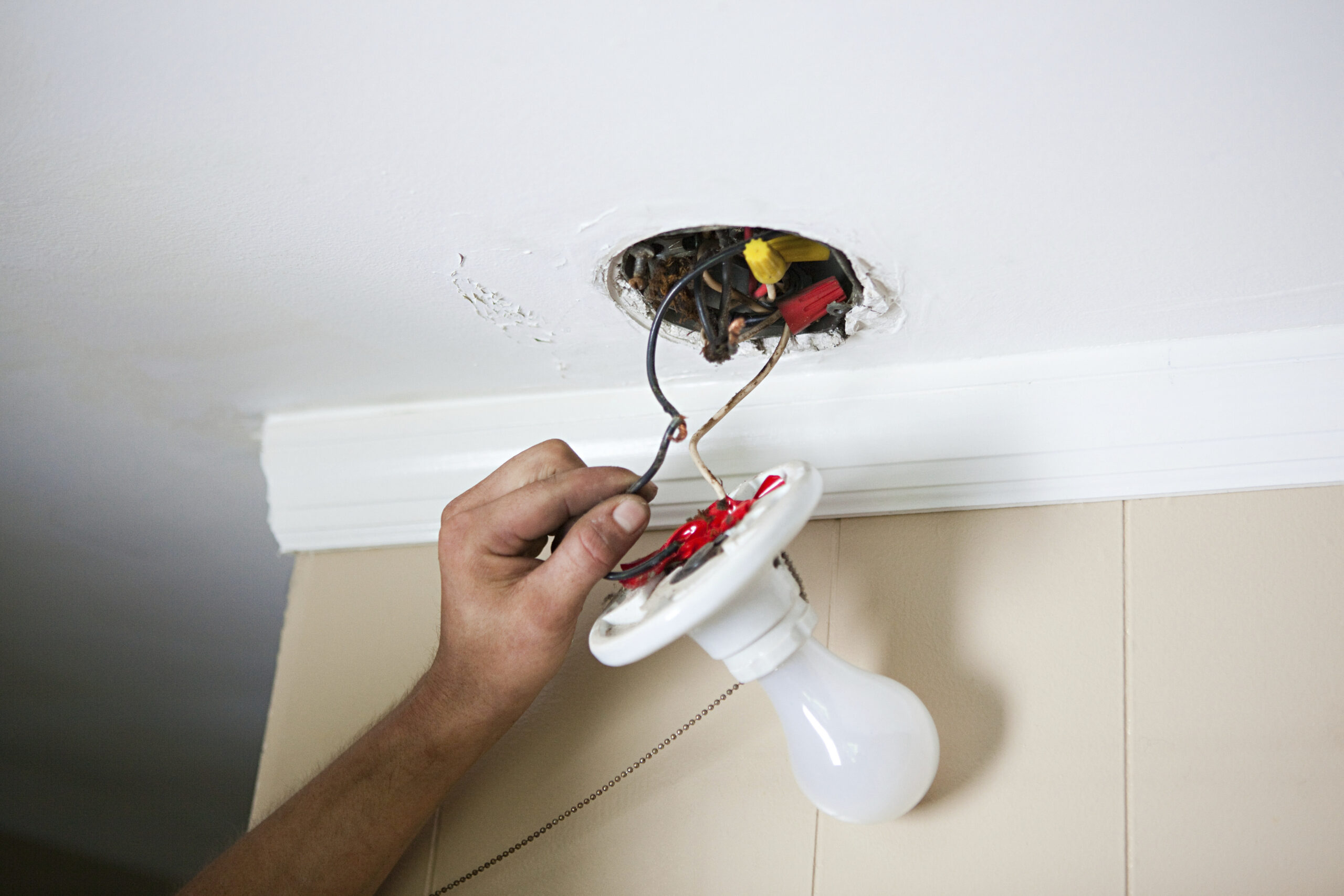 Electrician at work installing a light fixture