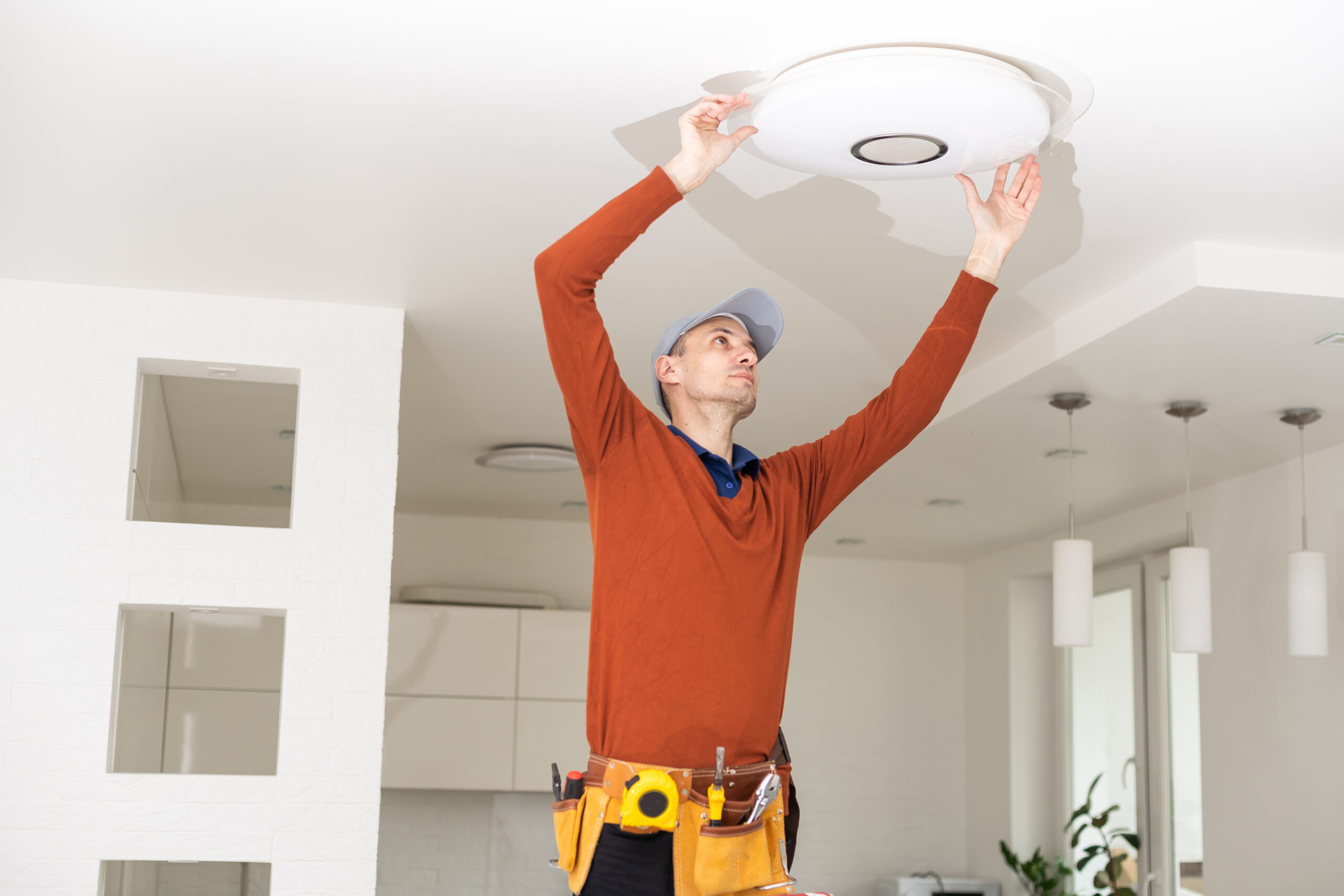 Electrician worker installation electric lamps light inside apartment. Construction decoration concept